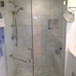shower doors custom with lots of light and marble tile